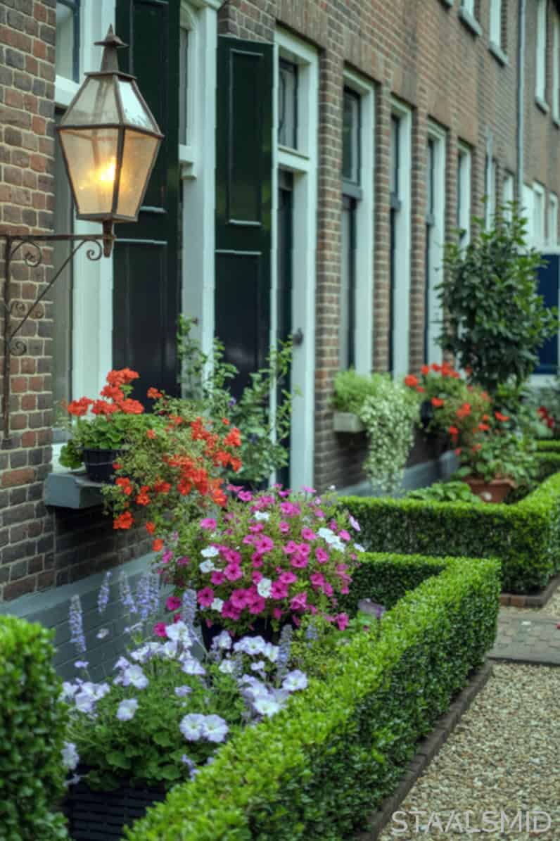 Sfeervolle kleine tuin aan de voorkant van een Nederlands rijtjeshuis, slim ingericht met inspirerende details